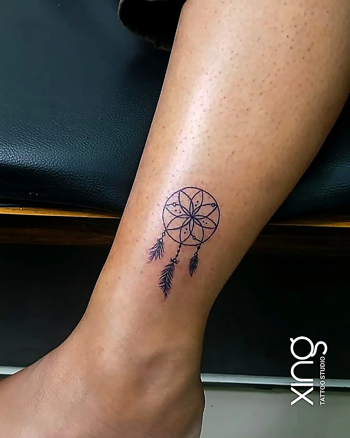 Fine-line dreamcatcher mandala tattoo on ankle