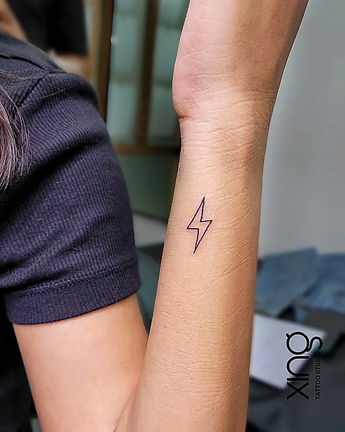 Minimalist lightning bolt tattoo on wrist