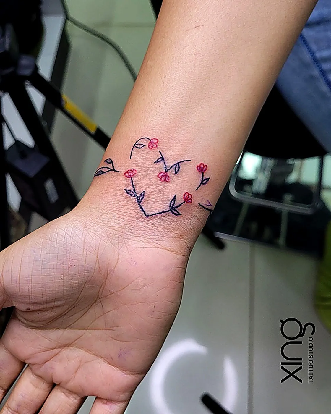 Fine-line floral heart tattoo on wrist — small tattoos from ₹1,499 at XING Tattoo Studio, Brookefield