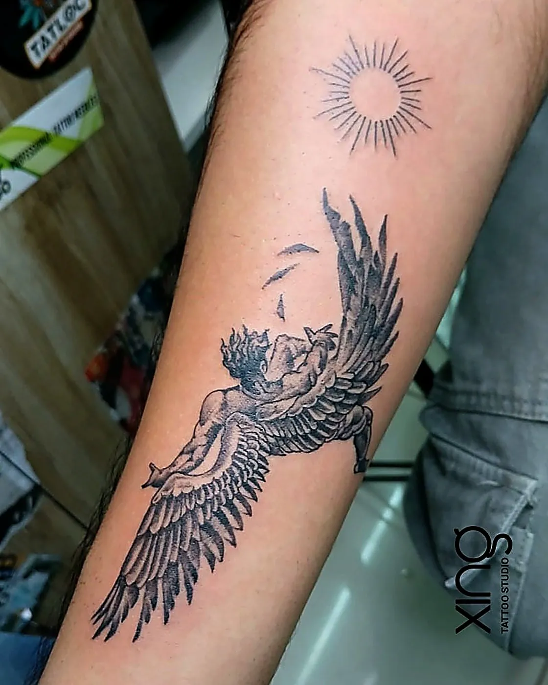 Realistic angel wings tattoo on forearm with fine feather detailing